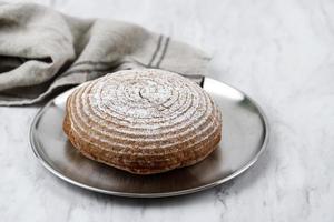 Boule rundes frisches rustikales Brot auf Silberplatte, foto