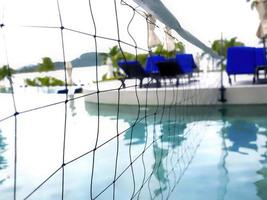 Detail des Volleyballnetzes über Blue Water Swimming Pool in einem Resort in Phuket, Thailand foto