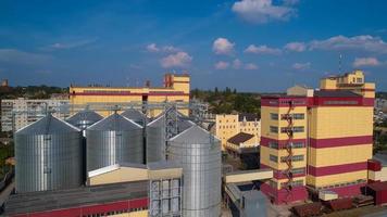 landwirtschaftliches Silo. lagerung und trocknung von getreide, weizen, mais, soja, gegen den blauen himmel mit wolken. foto