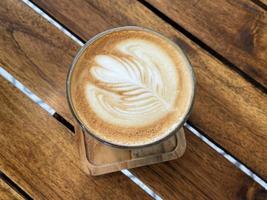 schöne tasse cappuccino mit latte art im holzraumhintergrund foto
