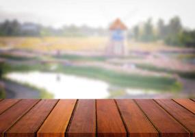 ausgewählter fokus leerer holztisch und blick auf viele blumen verwischen hintergrund mit bokeh-bild. für Ihre Fotomontage oder Produktpräsentation. foto