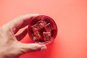 Erfrischungsgetränke in ein Glas mit Eiswürfel gießen foto