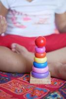 kind spielt mit einem babyspielzeug auf dem bett, kindentwicklungskonzept. foto