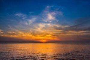 Sonnenunterganghimmel mit dramatischen Sonnenuntergangswolken über dem Meer. schöner sonnenaufgang über dem ozean foto