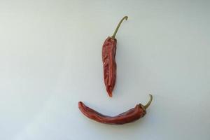 Rote reife Bio-Tomaten und getrocknete Paprika auf der Fensterbank in Form eines Smileys und Emoji foto