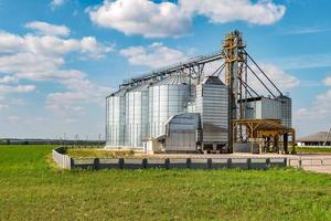 Silbersilos auf Agro-Produktionsanlage zur Verarbeitung, Trocknung, Reinigung und Lagerung von landwirtschaftlichen Produkten, Mehl, Getreide und Getreide. Getreidespeicher foto