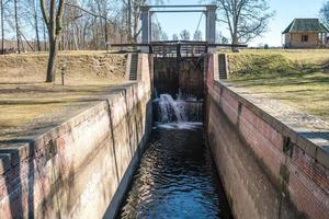 torschleuse zugbrücke bau auf fluss, kanal für vorbeifahrende schiffe bei unterschiedlichen wasserständen foto