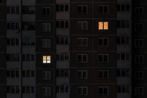 Flaches Nachtpanorama von Licht in Fenstern von mehrstöckigen Gebäuden. Leben in der Großstadt. konzept für ein verliebtes paar auf isolation foto