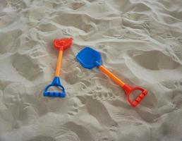 Schaufelspielzeug auf Sandkasten auf einem Spielplatz foto