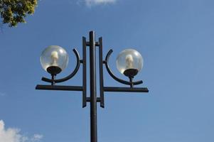 runde straßenlampe, stadtbeleuchtung im freien gegen den blauen himmel und die wolken. foto