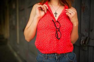 nahaufnahmefoto der brille auf frau, tragen auf roter bluse. foto