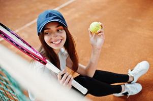 junge sportliche Spielerin mit Tennisschläger auf dem Tennisplatz. foto