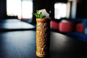Alkoholischer Cocktail mit Minze in ursprünglich Voodoo-Erdglas auf Stehtisch. foto