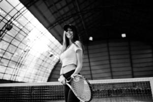 junge sportliche Spielerin mit Tennisschläger auf dem Tennisplatz. foto