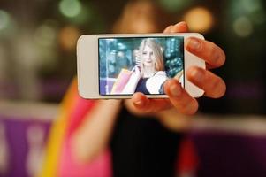 Mädchen mit Einkaufstüten auf dem Bildschirm am Telefon. foto