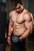 asiatische männer trainieren, indem sie gewichte heben oder hanteln heben. asiatisches Bodybuilder-Fitnesskonzept foto