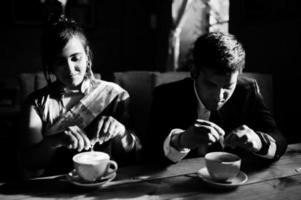 elegante und modische indische freunde paar frau im saree und mann im anzug sitzen im café und trinken cappuccino. foto