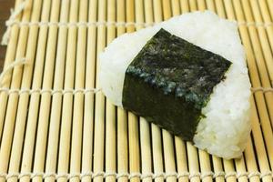 das japanische essen onigiri weißer reis in dreieckigen oder zylindrischen formen geformt und oft in nori gewickelt. foto