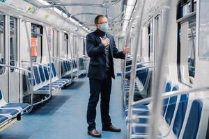 Coronavirus (COVID-19. Der kranke Mann fühlt sich unwohl, hat Atemnot, trägt eine medizinische Maske, posiert im U-Bahn-Wagen, schützt vor ansteckenden Krankheiten, vermeidet den Kontakt mit Menschen und Viren foto