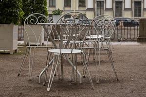 leeres café und weiße metalltische im park. Verbot des Besuchs öffentlicher Orte wegen der Bedrohung durch das Coronavirus. foto