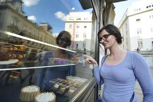 Frau vor süßem Schaufenster foto