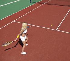 junge frau spielt tennisspiel im freien foto