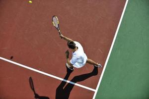 junger mann spielt tennis foto