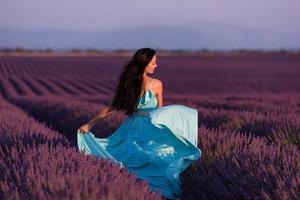 Frau auf dem Lavendelblumengebiet foto