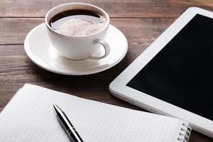 Tablette, Notizbuch und Kaffee auf dem Tisch
