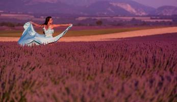 Frau auf dem Lavendelblumengebiet foto