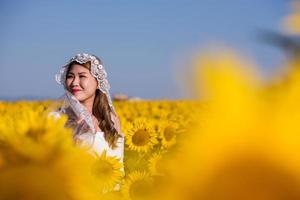 asiatische Frau am Sonnenblumenfeld foto