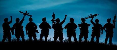 Silhouette des Militärsoldatenteams oder des Offiziers mit Waffen an foto