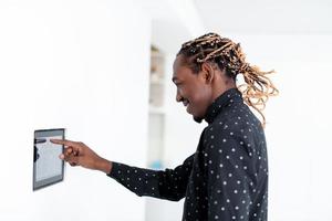 afrikanischer Mann mit Smart-Home-Bildschirm foto