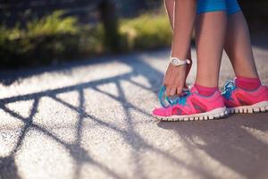 Nahaufnahme einer Frau, die Laufschuhe bindet foto