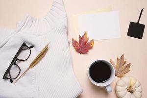 flache lage des herbstmodestils, pullover, brillen, kaffee und leere karte mit ahornblättern, draufsicht foto