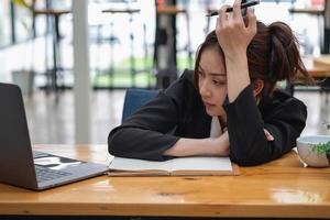 Burnout-Syndrom am Arbeitsplatz. erschöpfte überarbeitete frau, die im büro arbeitet.konzept burnout-syndrom. foto