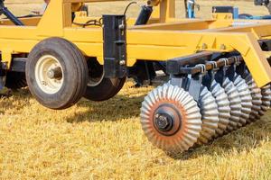 Wellenförmige Scheibenegge für die Feldarbeit auf einem landwirtschaftlichen Traktor an einem sonnigen Tag. foto