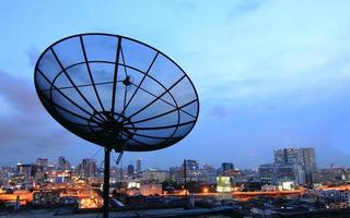 schwarze antenne kommunikation satellitenschüssel über sonnenuntergang himmel im stadtbild foto