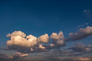 Hintergrund des blauen Himmels mit flauschigen, lockigen, rollenden Wolken am Abend. gutes windiges Wetter foto