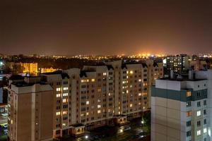 Nachtpanorama des Lichts in den Fenstern eines mehrstöckigen Gebäudes. Leben in einer Großstadt foto