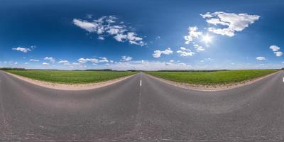 Vollständiges sphärisches, nahtloses Panorama 360-Grad-Winkelansicht auf verkehrsfreier Asphaltstraße zwischen Feldern mit bewölktem Himmel in gleichrechteckiger Projektion, vr ar-Inhalt foto