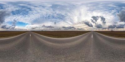 Vollständiges, nahtloses sphärisches HDRI-Panorama 360-Grad-Winkelansicht auf Asphaltstraße zwischen Feldern am Vorfrühlingstag mit Sonne am bewölkten Himmel in gleichrechteckiger Projektion, bereit für VR-AR-Inhalte foto