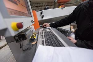 Tischler, die eine CNC-Holzbearbeitungsmaschine berechnen und programmieren foto