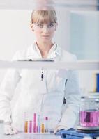 Forscherin hält ein Reagenzglas im Labor hoch foto
