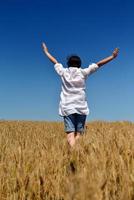 junge Frau im Weizenfeld im Sommer foto