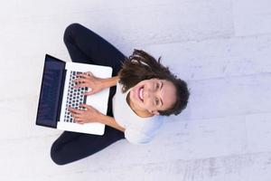 frauen, die laptop-computer auf der draufsicht des bodens verwenden foto