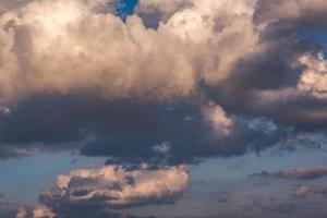 Hintergrund des blauen Himmels mit flauschigen, lockigen, rollenden Wolken am Abend. gutes windiges Wetter foto