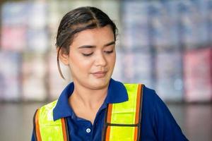 porträt einer jungen lagerarbeiterin, die im lager steht, arbeiterin, die in der logistikindustrie im fabriklager arbeitet foto