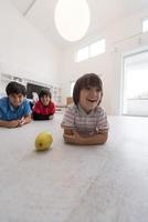 Jungs haben Spaß mit einem Apfel auf dem Boden foto