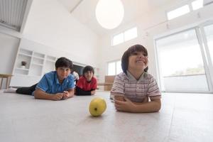 jungen, die spaß mit einem apfel auf dem boden haben foto